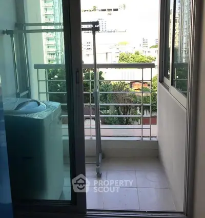Charming balcony with washing machine and city view, perfect for urban living convenience.