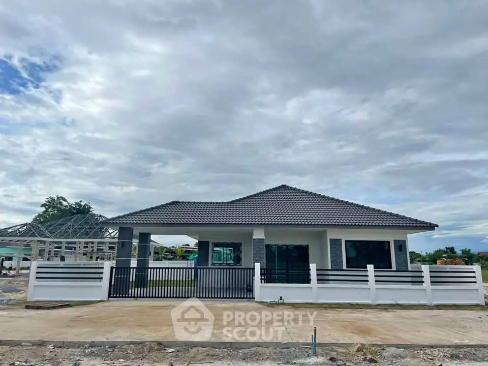 Modern single-story house with a sleek roof and spacious front yard.