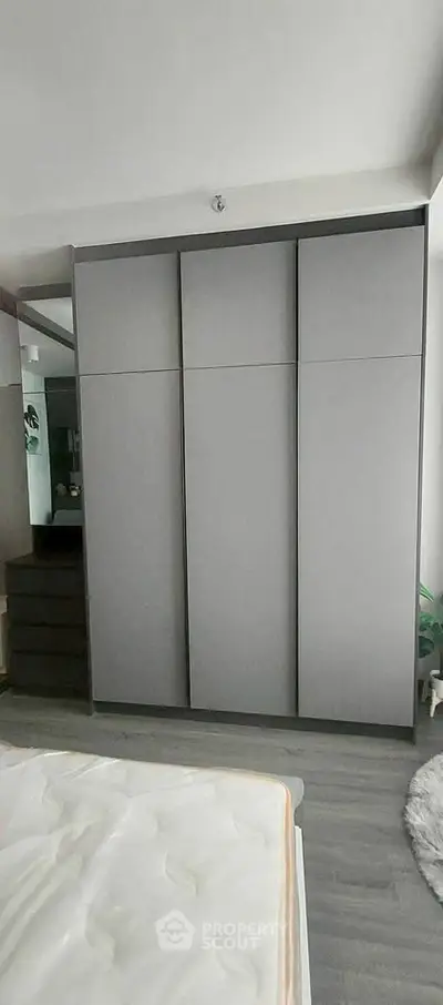 Modern bedroom with sleek gray wardrobe and minimalist design