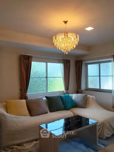 Elegant living room with chandelier and cozy sectional sofa, perfect for relaxation and entertaining.