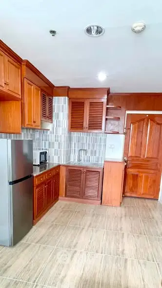 Spacious kitchen with wooden cabinets and modern appliances in a stylish apartment.