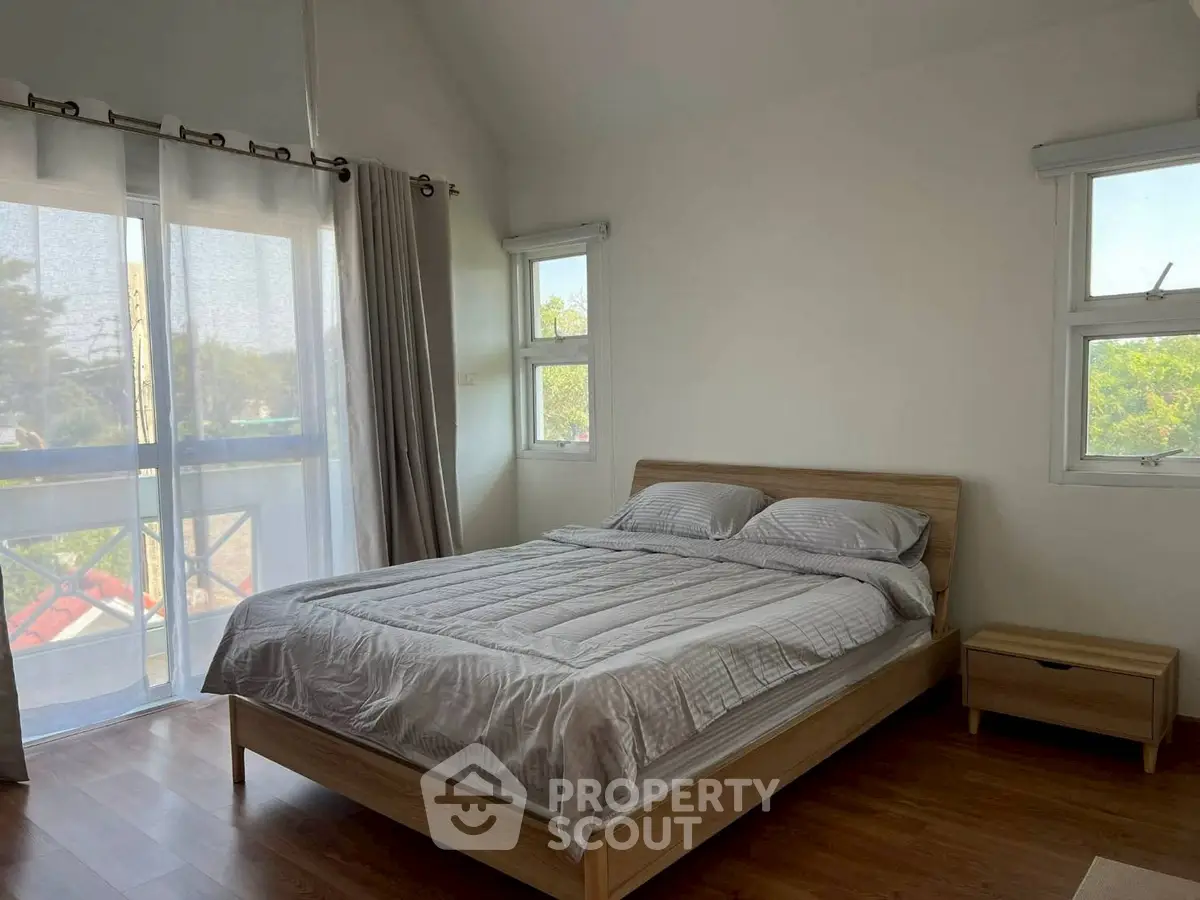 Spacious bedroom with large windows and natural light