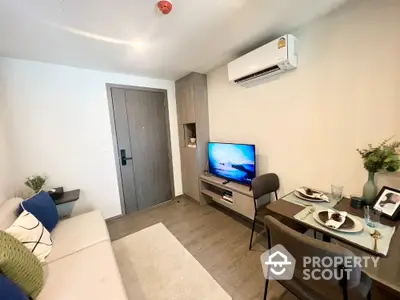 Modern living room with cozy sofa, dining area, and wall-mounted TV in stylish apartment.