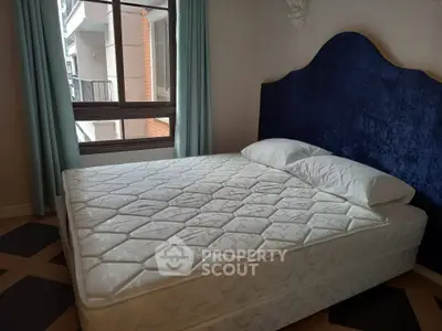 Cozy bedroom with elegant blue headboard and large window view