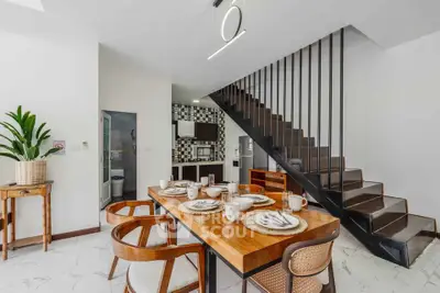 Modern dining area with stylish staircase and open kitchen layout
