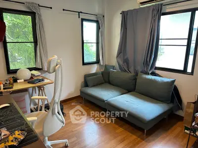 Cozy living room with modern furniture and natural light from large windows.
