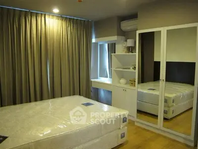 Spacious bedroom with mirrored wardrobe and cozy lighting in modern apartment.