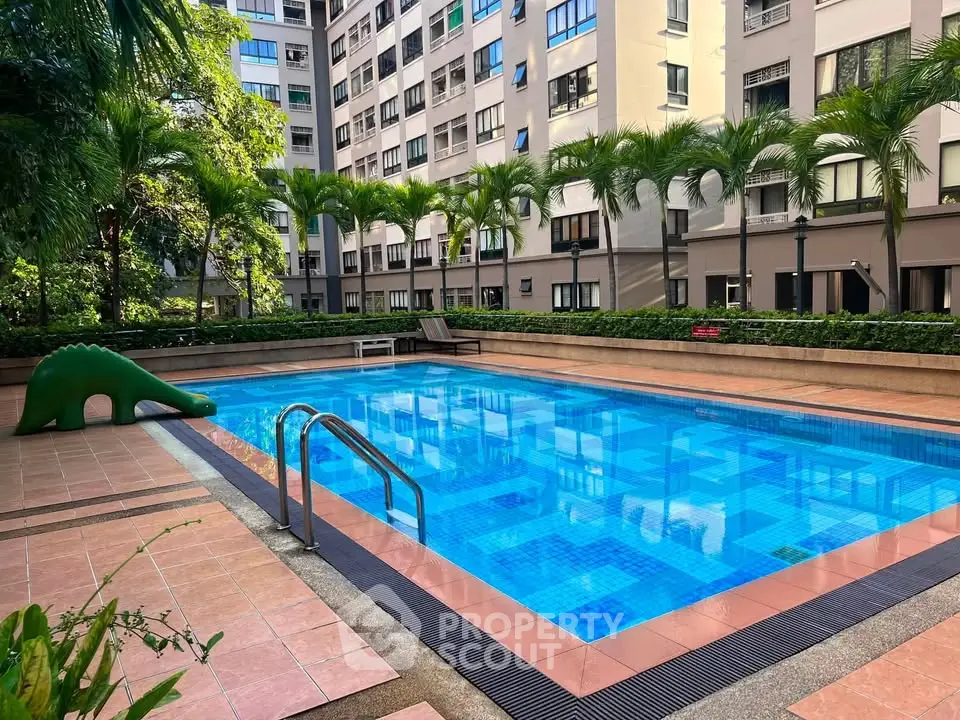 Luxurious condominium pool area with lush greenery and modern design, perfect for relaxation and leisure.
