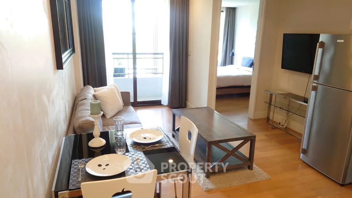 Modern apartment interior with cozy living room and dining area, featuring a balcony view.