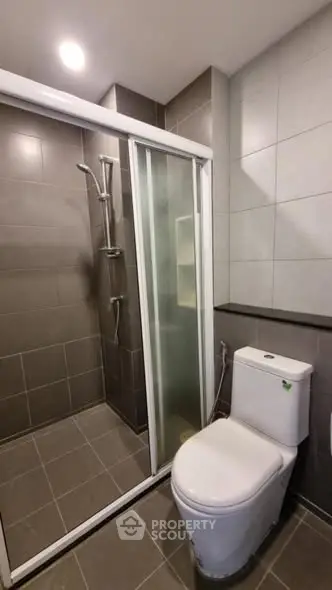 Modern bathroom with sleek shower and toilet in contemporary design.