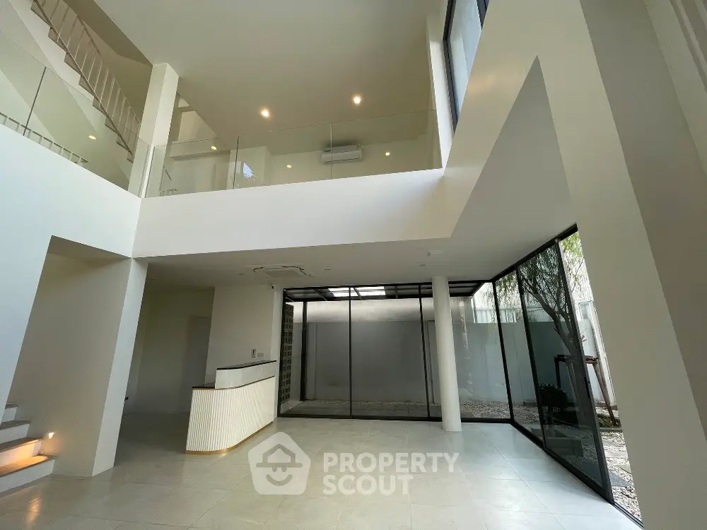 Spacious modern living room with high ceilings and large windows for natural light.