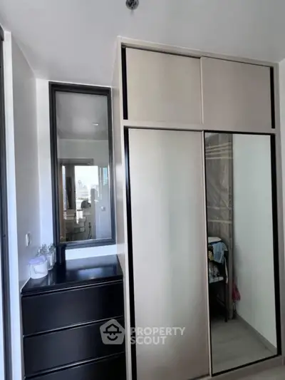 Modern bedroom with sleek wardrobe and dresser, reflecting minimalist design.