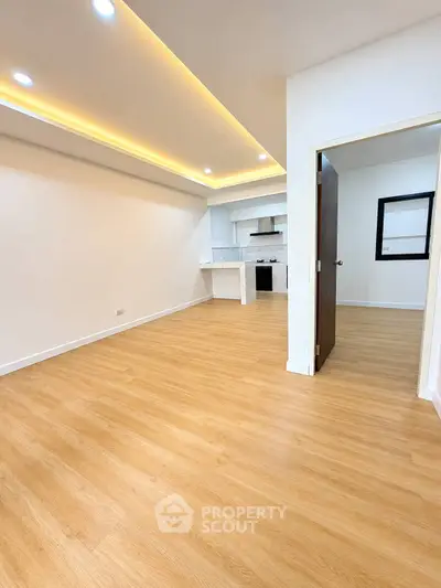 Modern open-plan living room with wooden flooring and recessed lighting