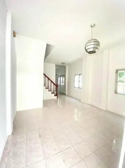 Spacious bright living area with tiled flooring and modern lighting in a stylish home.