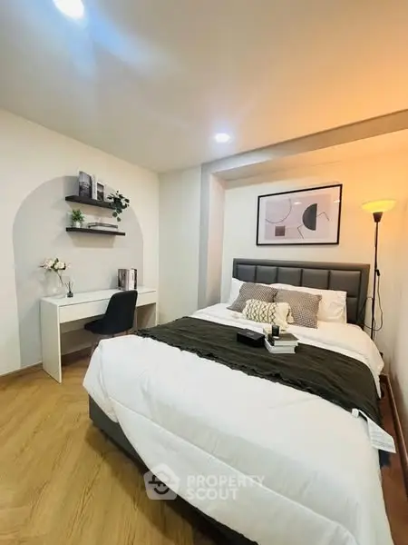 Cozy bedroom with modern decor and study area, perfect for relaxation and productivity.
