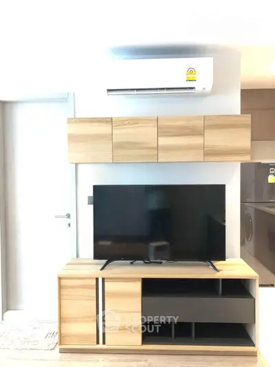 Modern living room with sleek TV stand and wall-mounted air conditioner in stylish apartment.