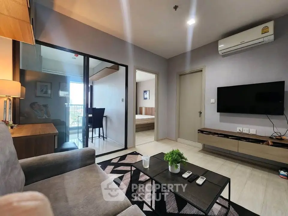 Modern living room with sleek furniture and balcony view in a stylish apartment.