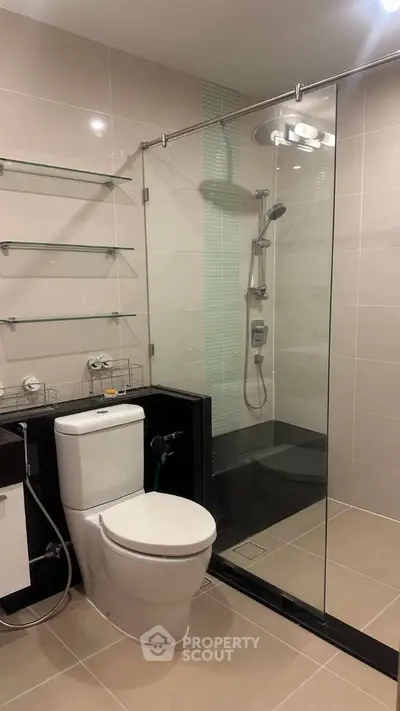 Modern bathroom with glass shower and sleek fixtures in a contemporary apartment.