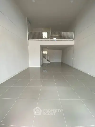 Spacious open-plan interior with high ceilings and mezzanine level, perfect for modern living.