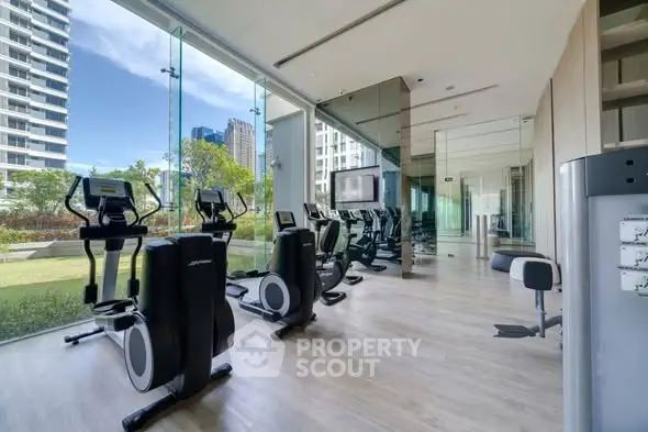 Modern gym with state-of-the-art equipment and scenic outdoor view in luxury residential building.