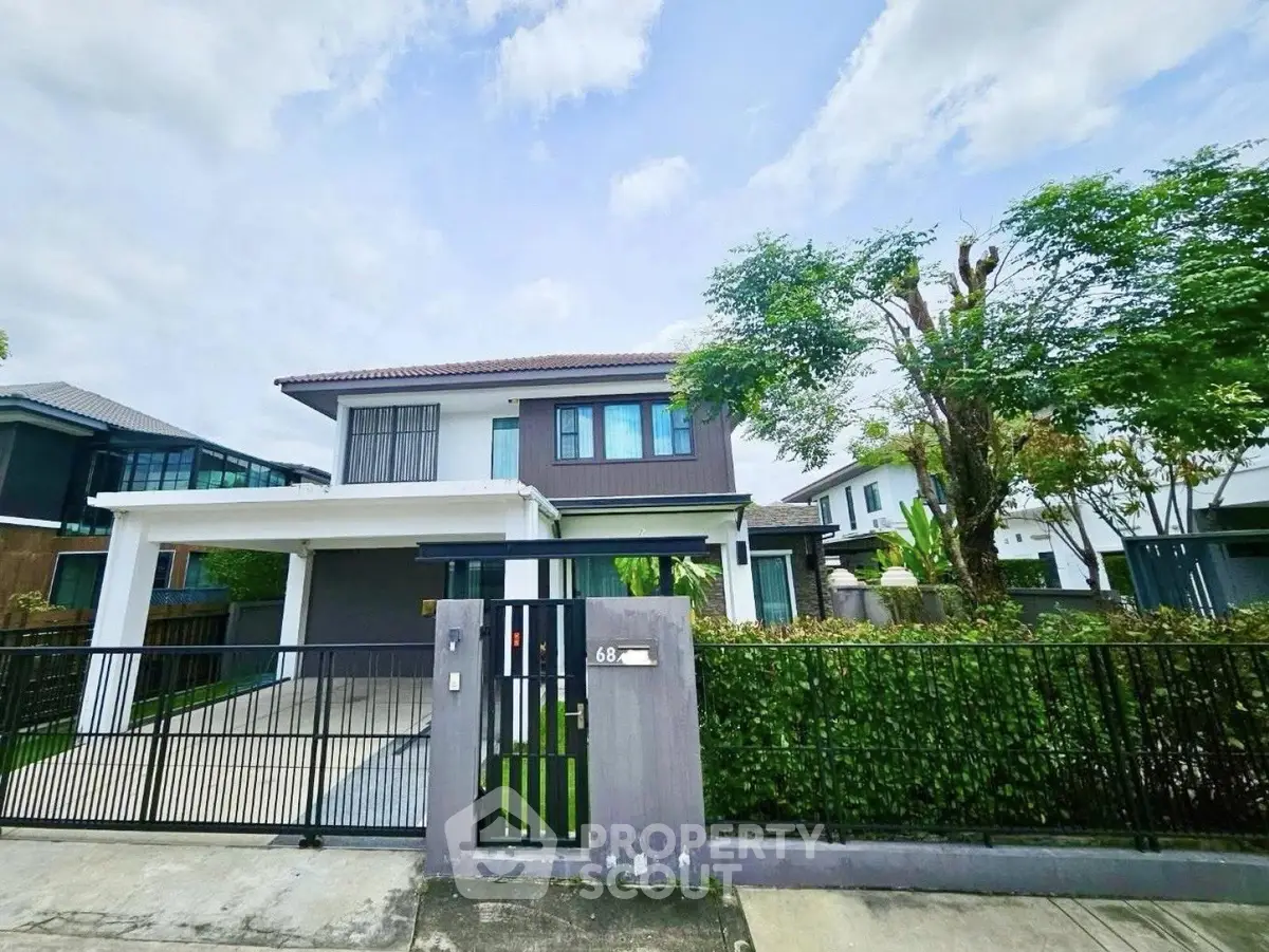 Modern two-story house with lush greenery and spacious driveway in a serene neighborhood.