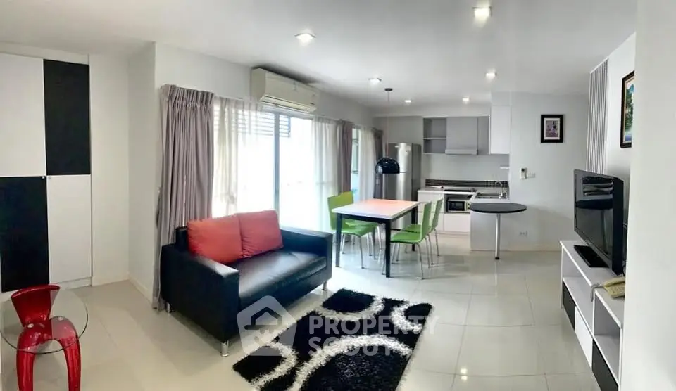 Modern open-layout living room with stylish furniture and kitchen area