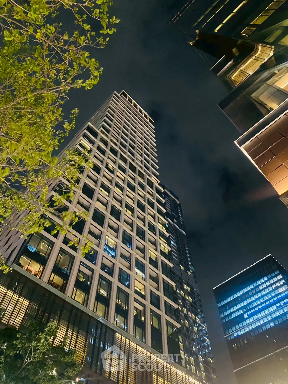 Stunning night view of modern high-rise building with illuminated windows and sleek architecture.