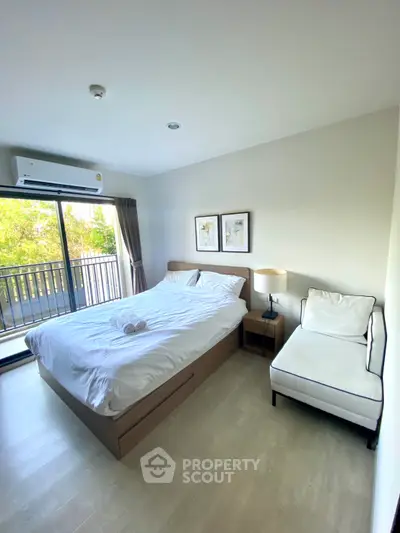Bright and cozy bedroom with balcony view, modern furnishings, and natural light.