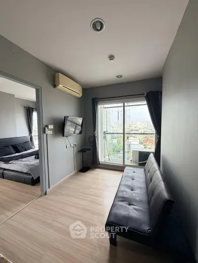 Modern apartment living room with city view, featuring sleek furniture and large windows for natural light.