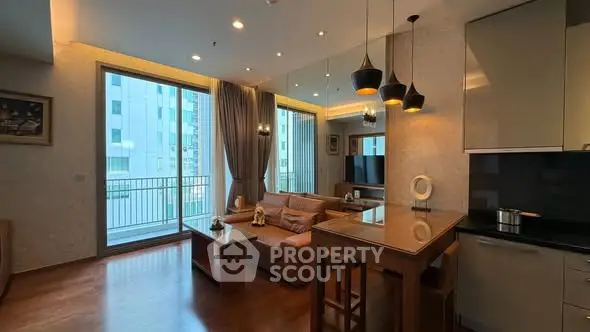 Modern living room with open kitchen and large windows in a stylish apartment.