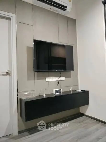 Modern living room with wall-mounted TV and sleek black console