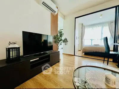 Modern living room with sleek TV unit and view into cozy bedroom, featuring stylish decor and natural light.
