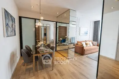 Modern open-plan living and dining area with stylish decor and wooden flooring.