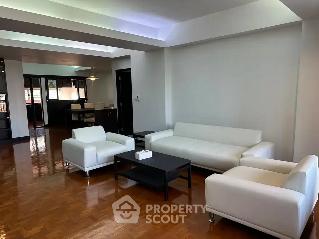 Spacious living room with modern white sofas and wooden flooring
