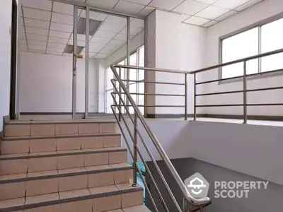 Modern office stairway with glass doors and metal railings