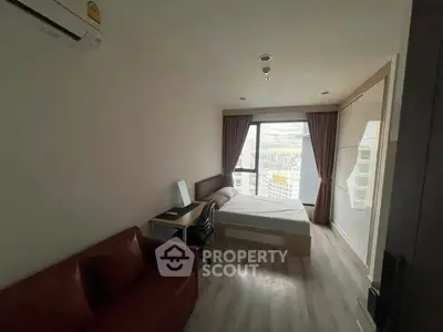 Modern bedroom with city view, featuring a cozy bed, desk, and air conditioning, perfect for urban living.