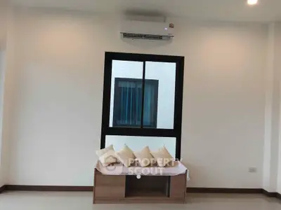 Modern living room with air conditioning and cozy seating area under window.