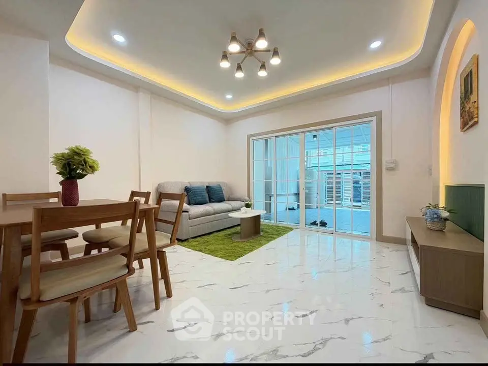 Modern living room with elegant lighting and spacious layout, featuring a cozy sofa and dining area.
