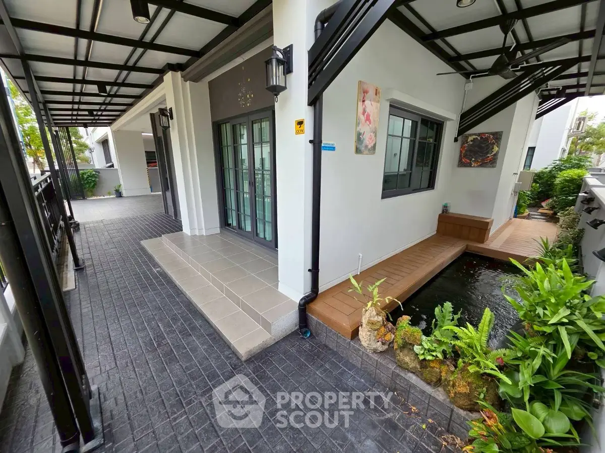 Modern home exterior with stylish patio and serene garden pond