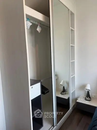 Modern bedroom with sleek mirrored wardrobe and stylish bedside lamp