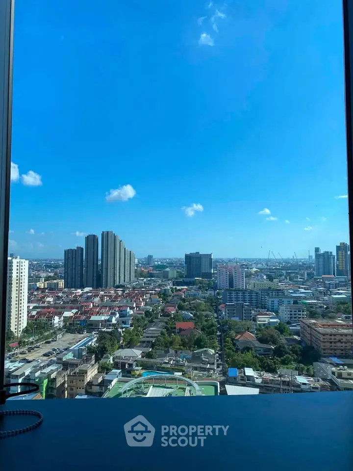 Stunning cityscape view from high-rise building window showcasing urban skyline and clear blue sky.