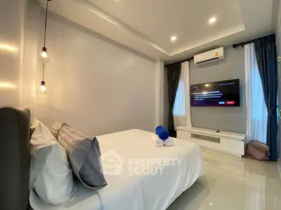 Modern bedroom with sleek design, featuring a wall-mounted TV and ambient lighting.