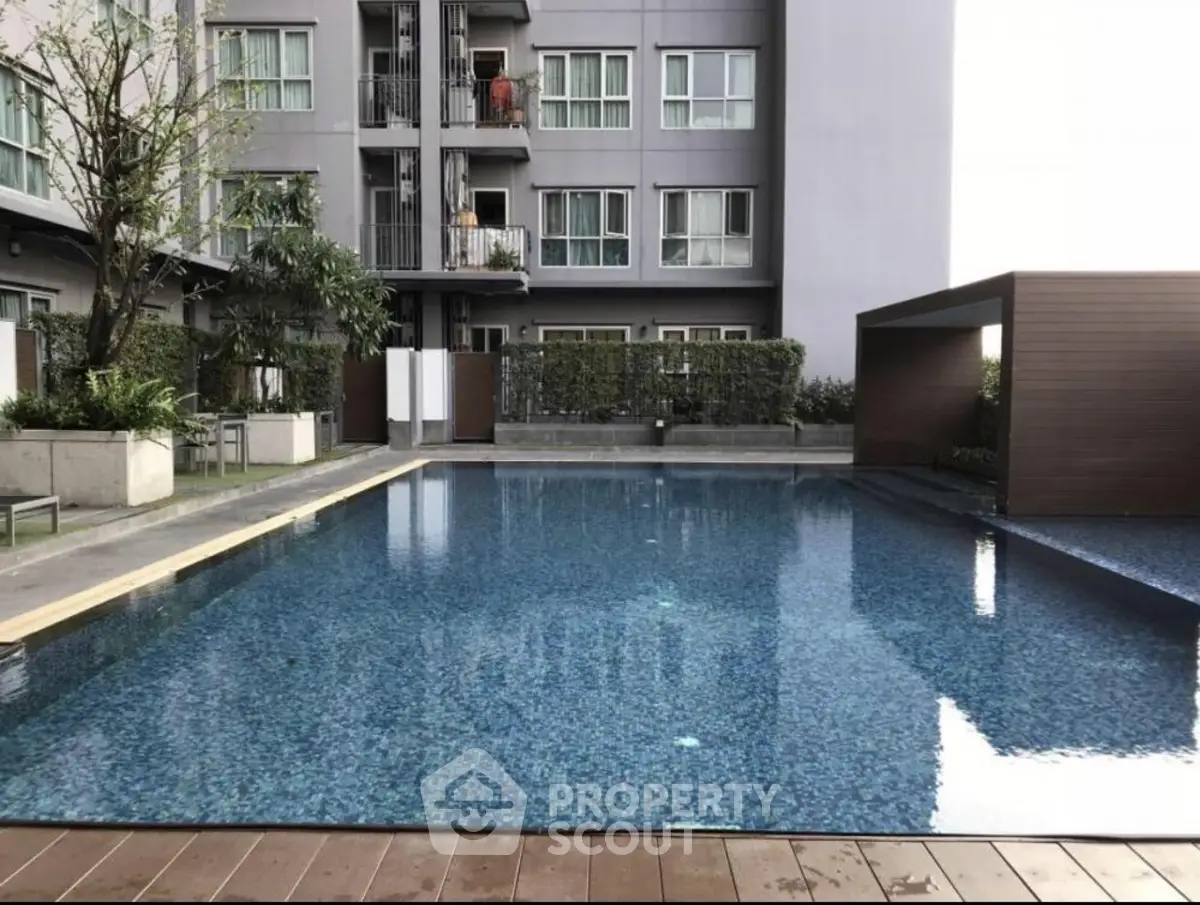 Modern apartment complex with a luxurious outdoor swimming pool and stylish architecture.