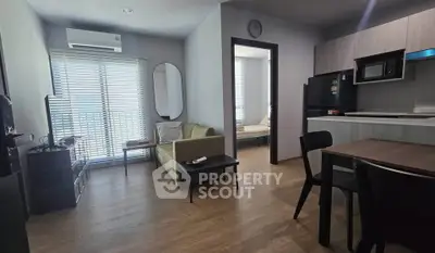 Modern living room with open kitchen and cozy seating area in a stylish apartment.