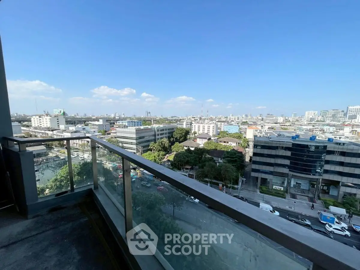Stunning cityscape view from a high-rise balcony with clear blue skies.