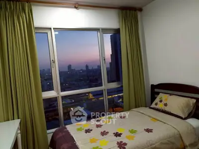 Cozy bedroom with city view, featuring a single bed and large window with green curtains.