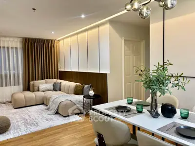 Modern living room with elegant dining area, featuring stylish furniture and warm lighting.