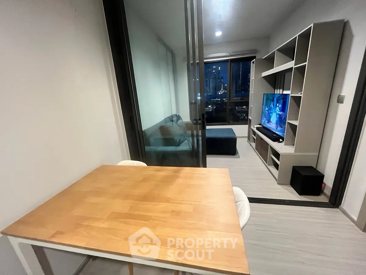 Modern living room with city view, featuring sleek furniture and a cozy atmosphere.