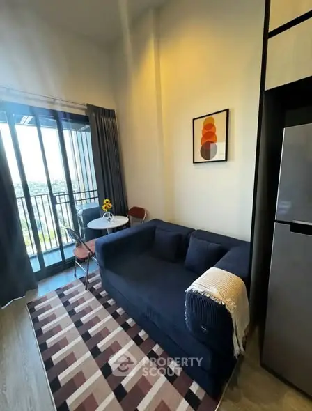 Modern living room with balcony view, stylish sofa, and chic decor in a cozy apartment setting.