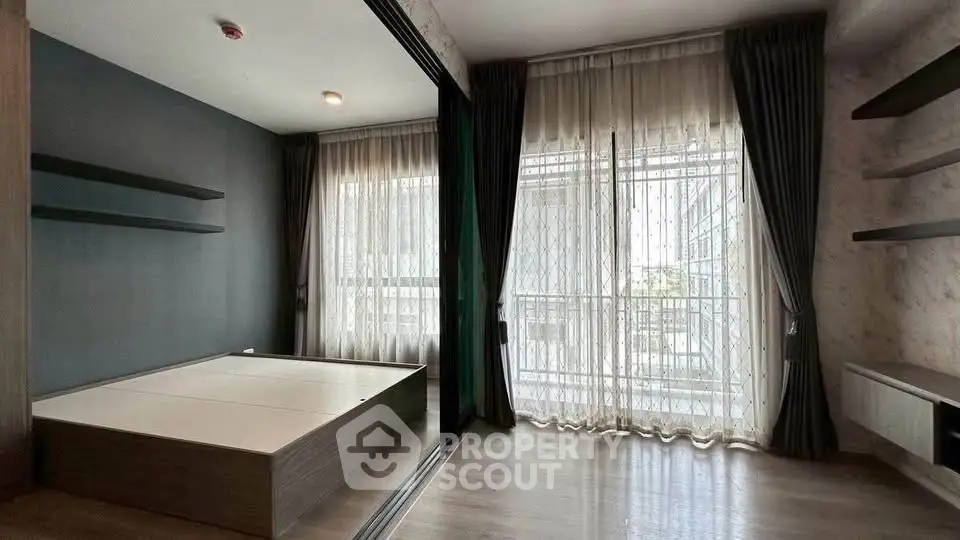 Spacious modern bedroom with large windows and elegant curtains in a stylish apartment.